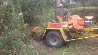 Uitfrezen van stronken met een stronkes frees achter een tractor boomstronk uitfrezen